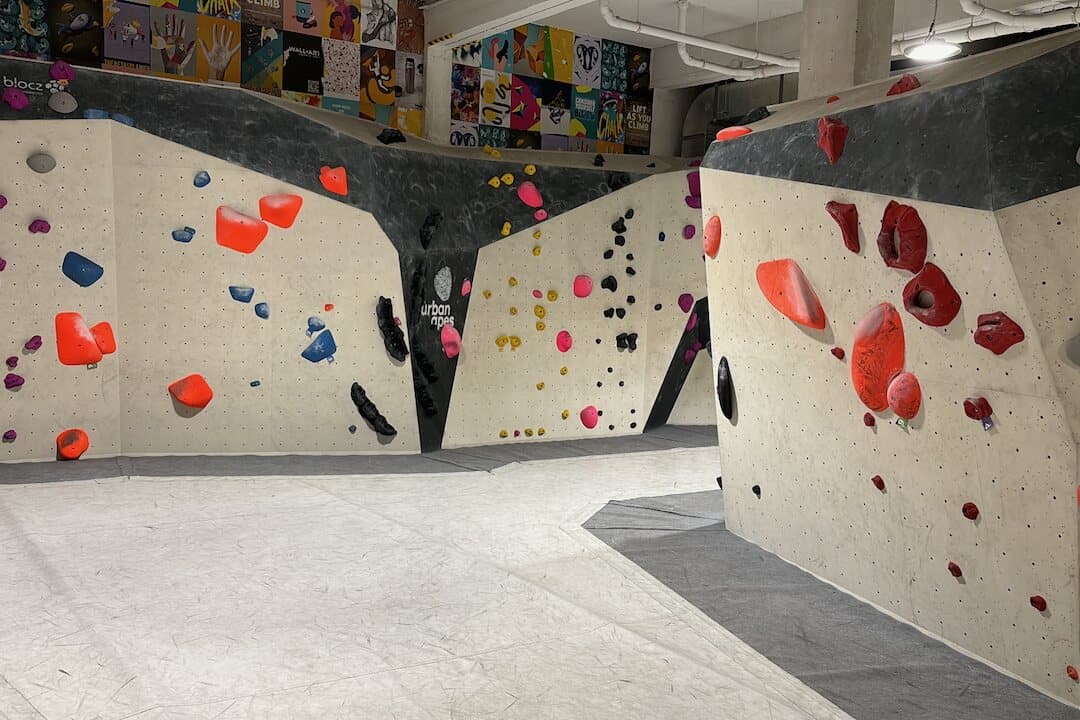 A bright indoor bouldering gym with colourful holds and padded floors.