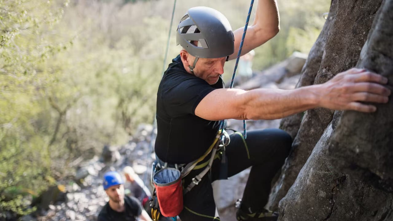 Older climber on a route, climbing for life