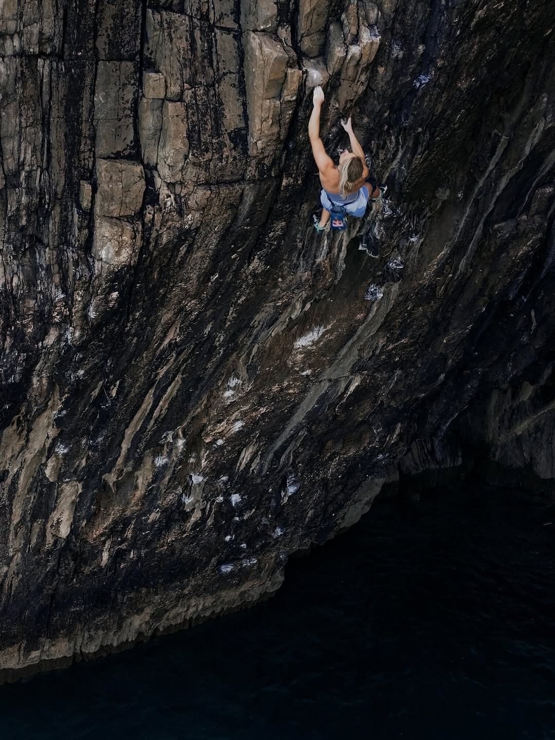 Deep water solo climbing above the sea on Olympiad