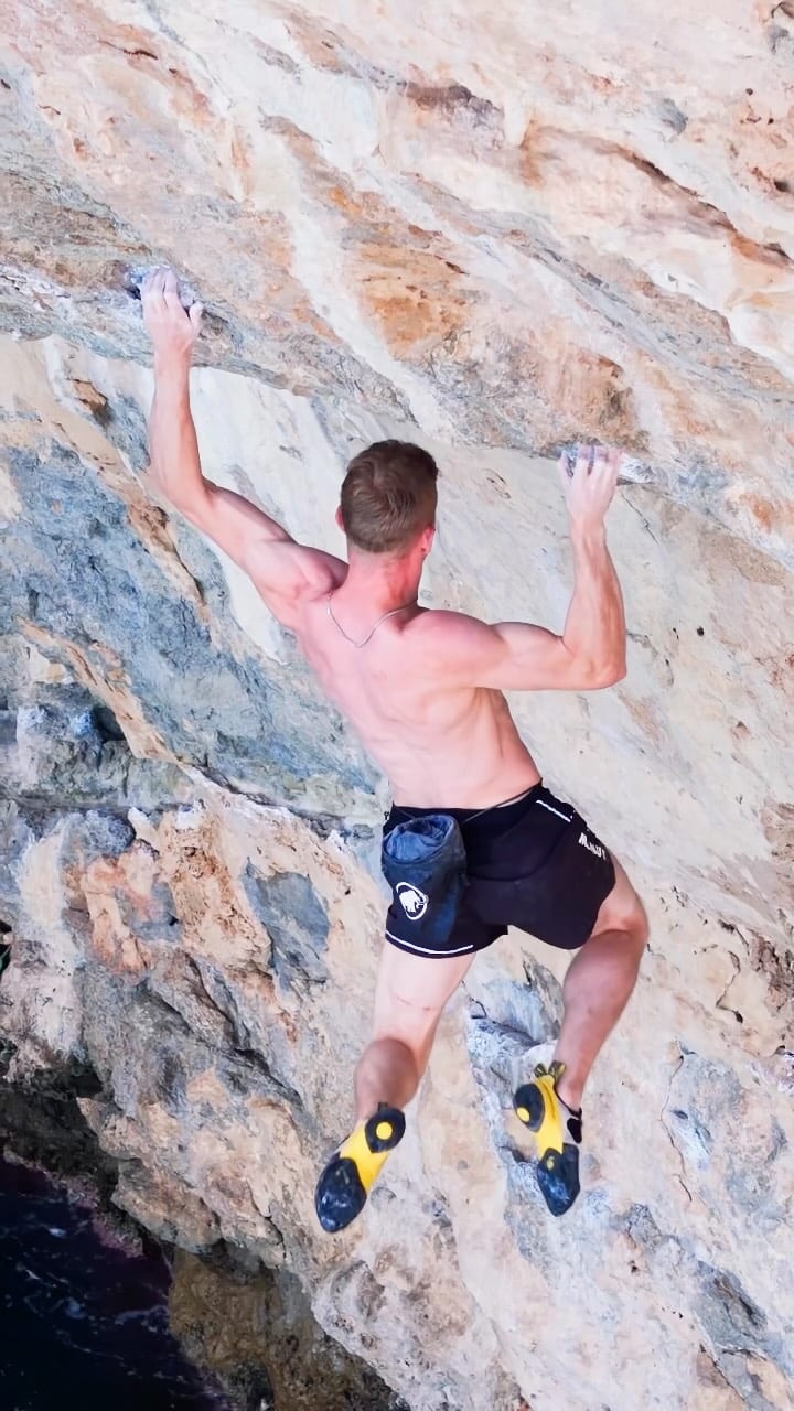 Jakob Schubert climbing above the sea at Canyamel in Mallorca