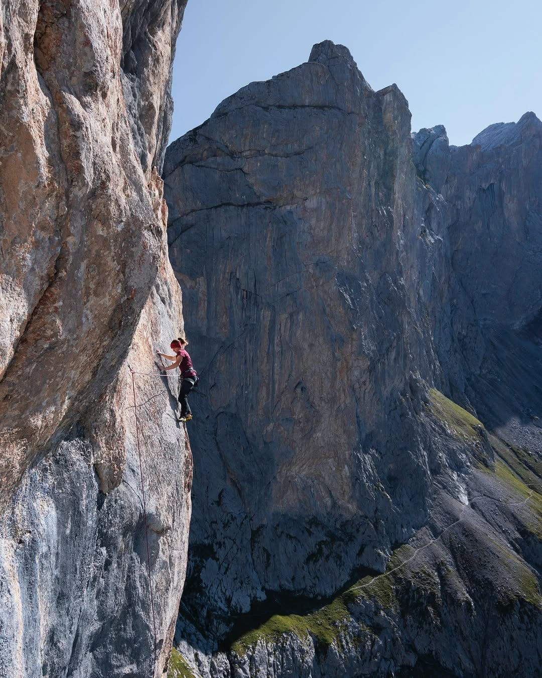 Climber on the steep grey limestone of the Rätikon high above the valley