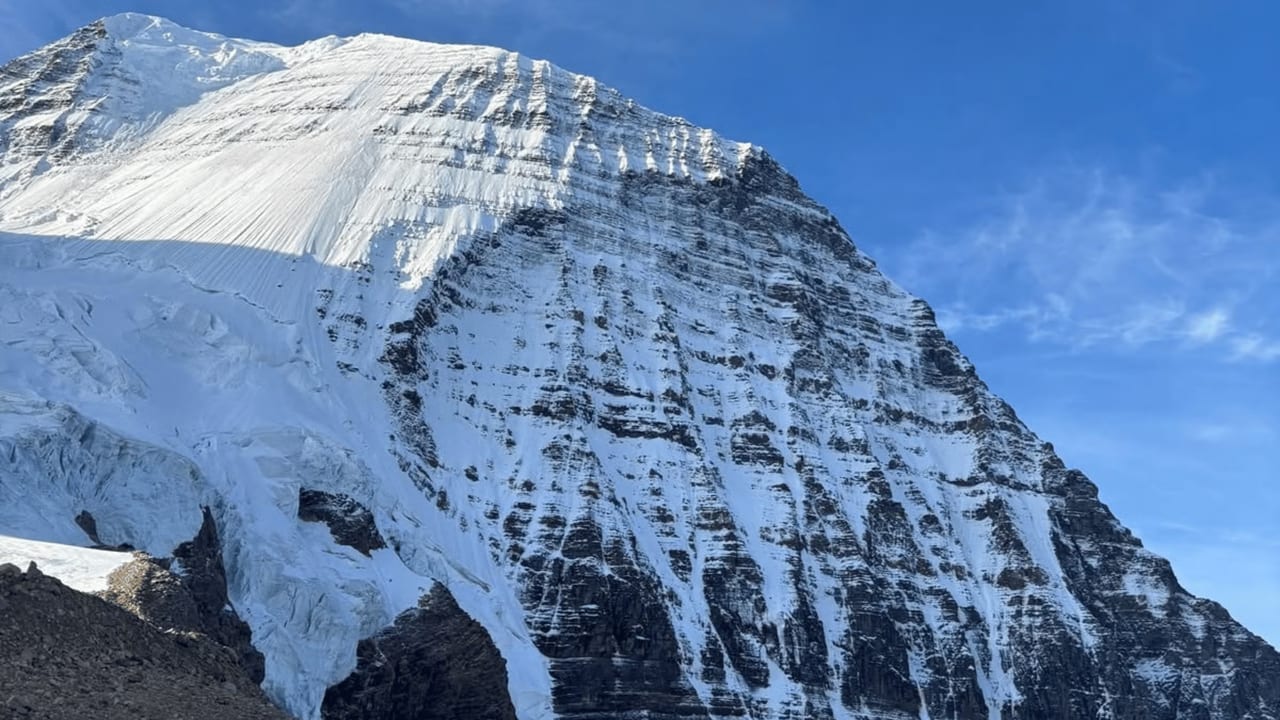 The snow-covered Emperor Face of Mount Robson under a blue sky