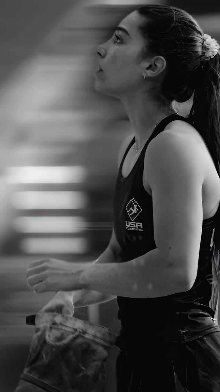 Black and white portrait of a USA Climbing athlete looking up at the wall